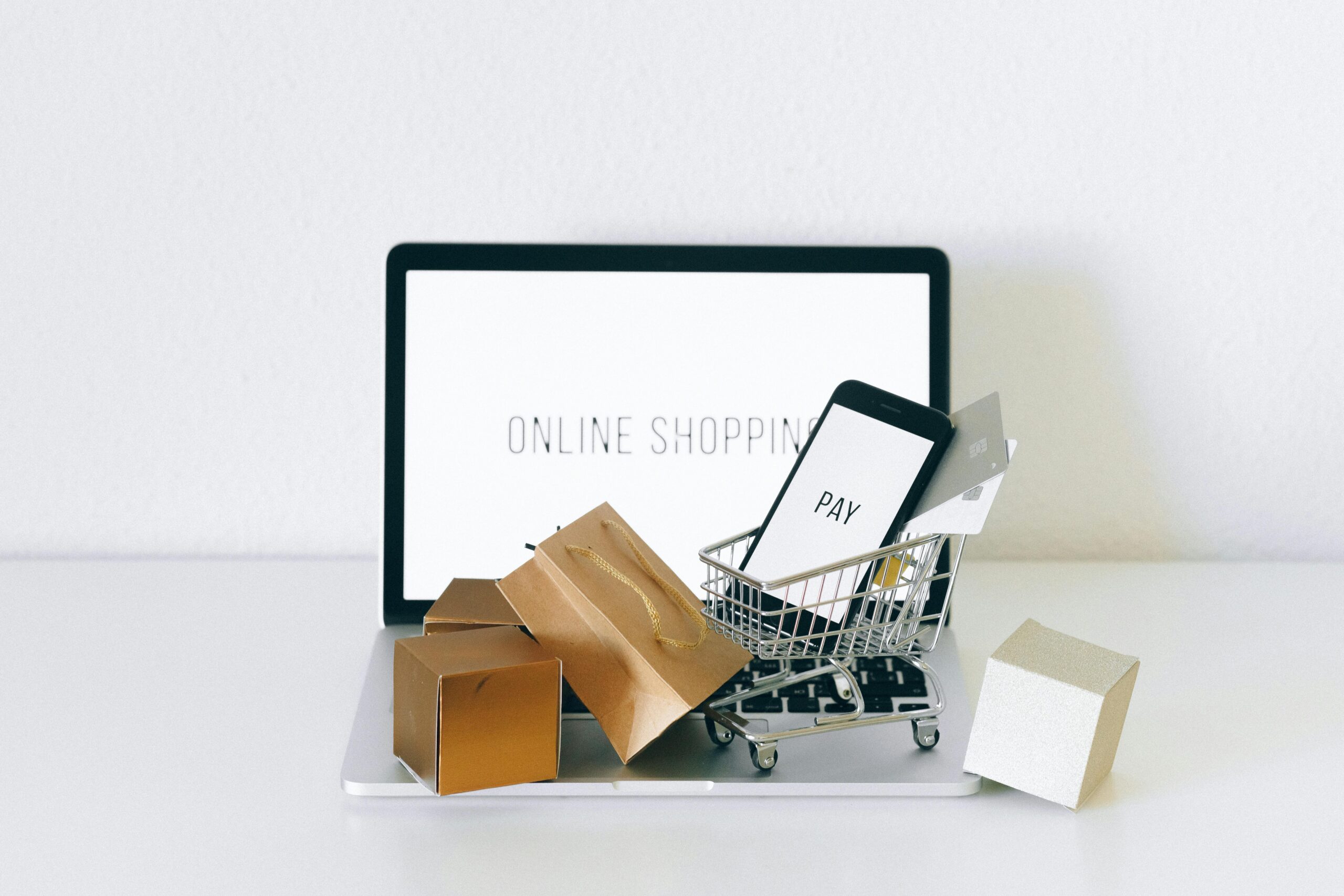 laptop mit einkaufswagen. am bildschirm steht "online shoping"